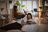 Mother and daughter reading book and using digital tablet