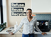 Confident businesswoman at recycling bins in office kitchen