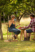Couple taking break from gardening at garden table