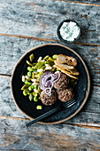 Stuffed meat patties with a bean salad and crispy bread chips