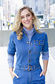 A young blonde woman wearing blue denim dungarees
