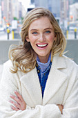 A young blonde woman wearing a white coat