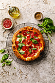 Scharfe Salami-Pizza mit Basilikum auf Abkühlgitter