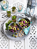 Pickled olives in bowls on a tray with mint tea