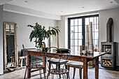 Metal chairs at the wooden table in the rustic dining room with stove