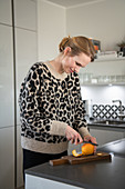 Blonde woman filleting an orange