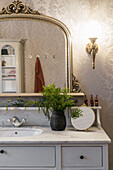 Bathroom vanity, above antique mirror on wall with wallpaper in bathroom