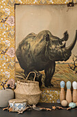 Vintage poster with rhinoceros motif on wall with floral wallpaper
