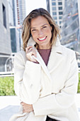 Joyful woman in white coat