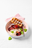 Gluten-free waffles with red fruit jelly and whipped cream