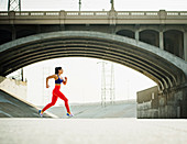 Sportliche Frau beim Joggen im urbanen Umfeld