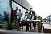 Business people working with laptops and tablet on balcony