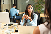 Attentive businesswoman listening to colleague in office