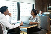 People with laptop meeting at booth in office cafeteria