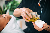 Pouring ethereal ayurvedic oil into a bowl