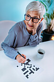 Senior woman solving crossword puzzle