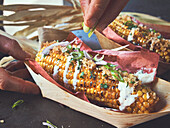 Grilled corn on the cob with crema and spices