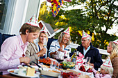 Fröhliche Menschen feiern das Flusskrebsfest im Freien (Schweden)