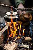 Kettle hanging over campfire