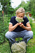 Mature woman smelling elderflowers