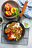 Grilled peaches and chicken with burrata garnished with pesto