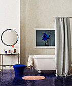 Duschvorhang vor frei stehender Badewanne im Badezimmer mit blau lackiertem Boden