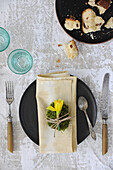 Moosei mit Narzisse auf der Serviette auf rustikal gedecktem Tisch