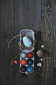 Egg carton with hay and colored Easter eggs