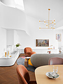 Living room with white, curved wall and elegant upholstered furniture