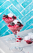 Berry granita in cocktail glasses against a blue background