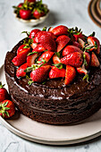 A chocolate cake decorated with fresh chopped strawberries