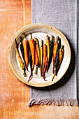 Grilled different colored carrots on ceramic plate