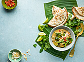 Vegetable curry and coconut roti on palm leaves
