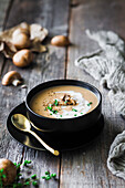 A bowl of mushroom soup on a wood table