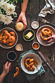 Frühstück mit Brezeln, Butter und Kaffee auf rustikalem Küchentisch