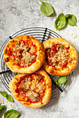 Mini pizzas - pizzette - topped with cheese and tomato plus Italian ham and chilli