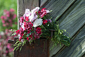 Bouquet of carnations with grass clamped to a door handle