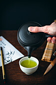 Japanischen grünen Tee in Teeschale einschenken