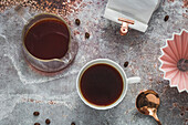 Filterkaffee in Tasse und Kanne daneben Origami-Kaffeefilter