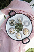 Hand-painted Easter eggs, quail eggs and daisies in vintage egg poaching pan