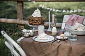 Gedeckter Ostertisch mit Eiern und Baiser im Garten