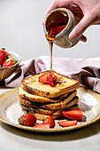 French toasts with fresh strawberries and maple syrup