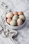 Fresh eggs in a bowl, on a marble surface