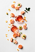 Rose wine and roses on white background