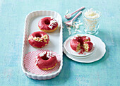Baked donuts with raspberry glaze and coconut flakes
