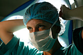 Surgeon ties her surgical mask around her face