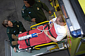 Paramedics load a patient into an ambulance