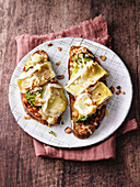 Country bread slices with broccoli, nuts and a double cheese topping