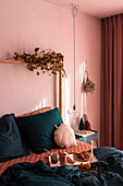 Frühstück im Bett im Schlafzimmer mit rosafarbener Wand