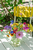 Colourful bouquet with cosmos and phlox on garden table